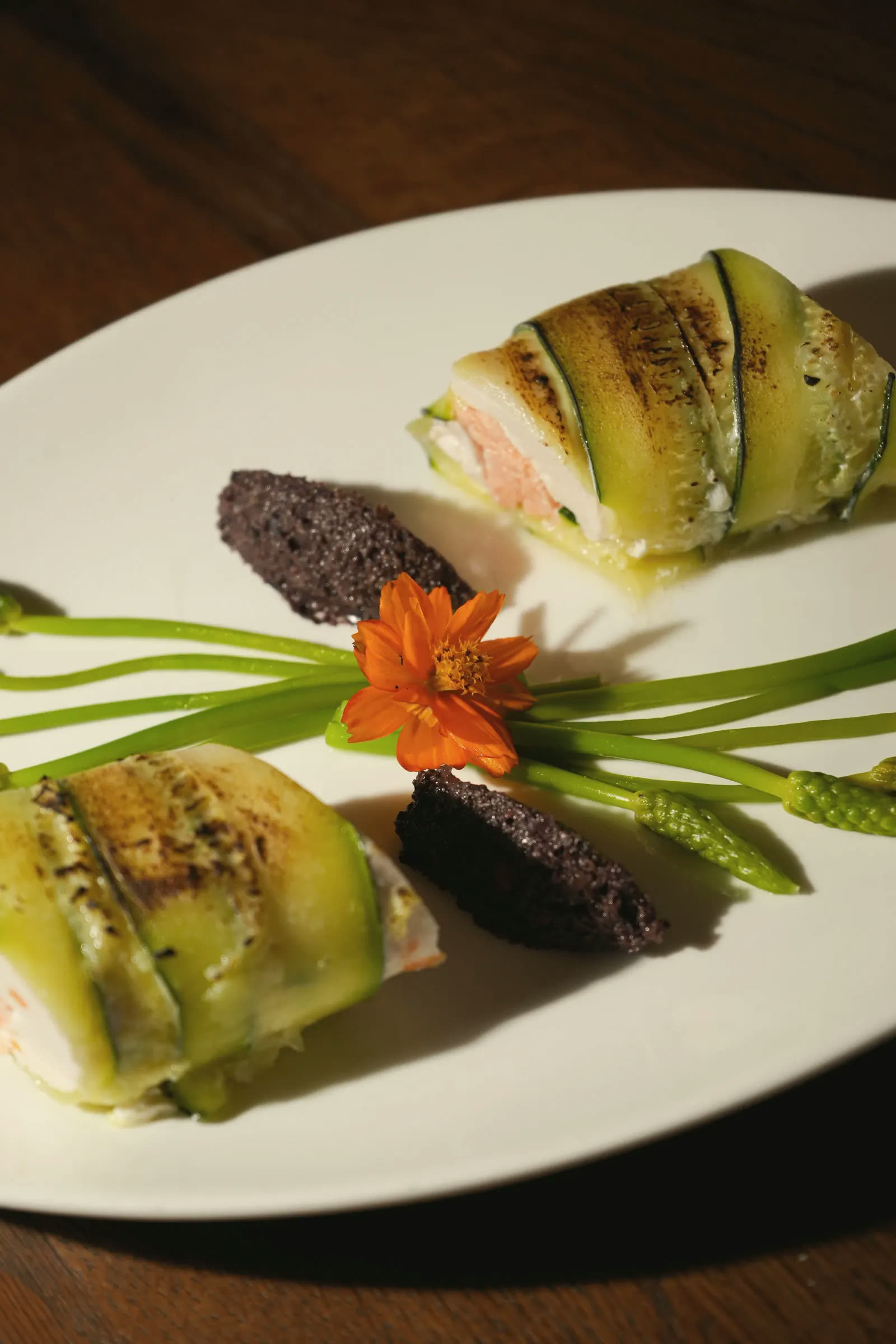 Salmon wrapped in grilled courgette, with chives and an orange flower