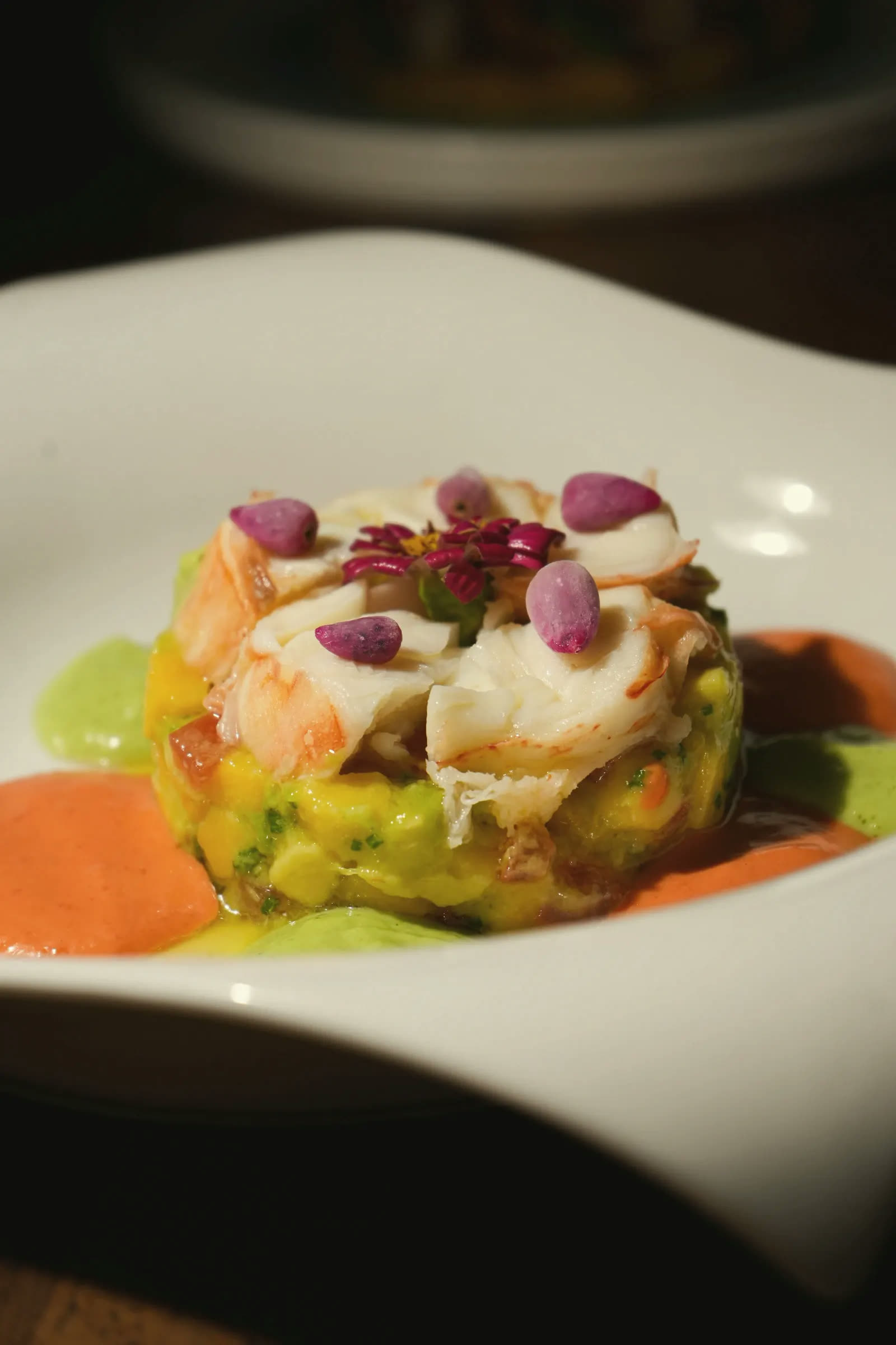 Lobster on a mango tartare, with edible flowers and two coulis