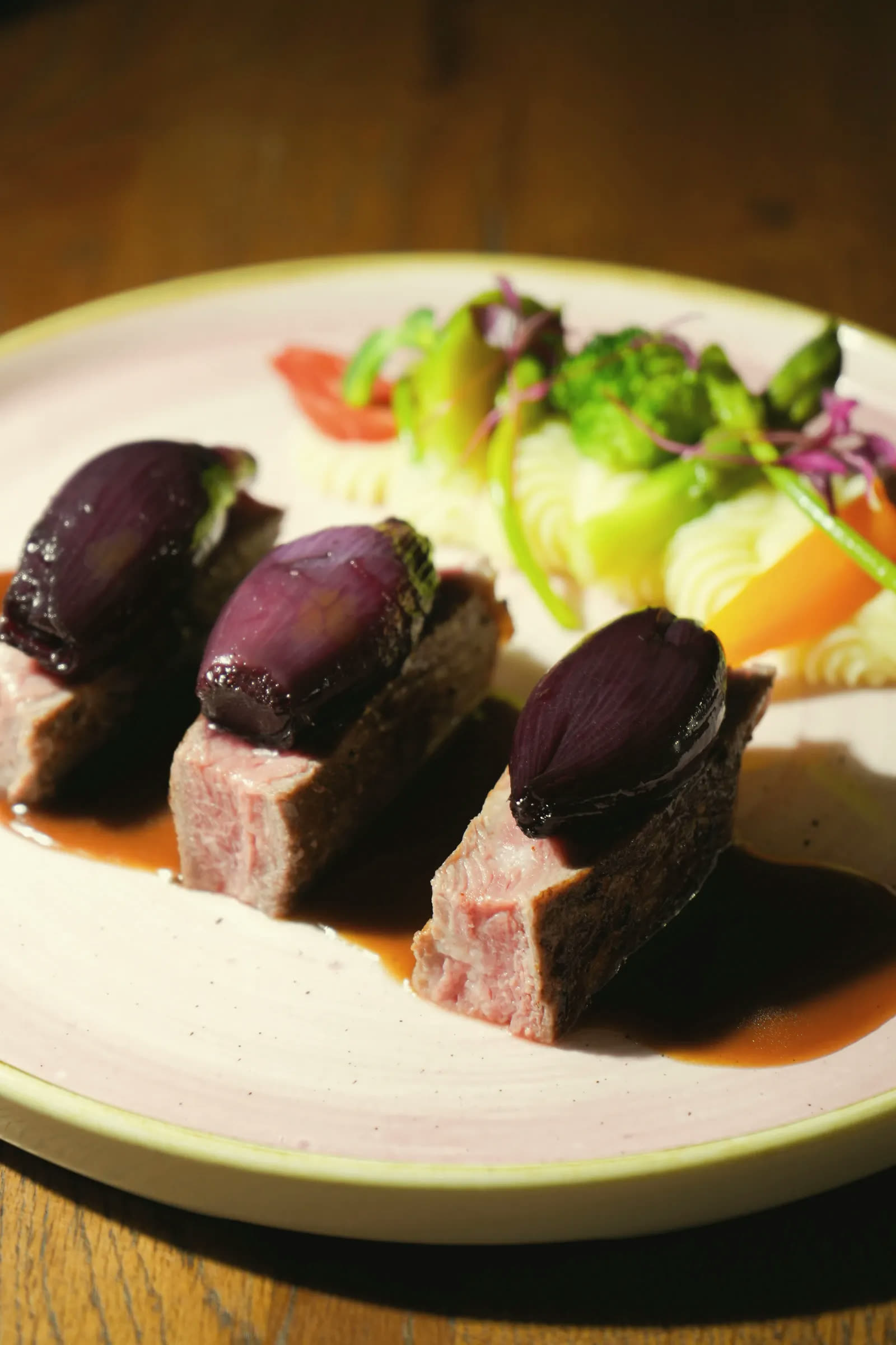 Sliced meat with wine-glazed shallots, a purée and vegetables