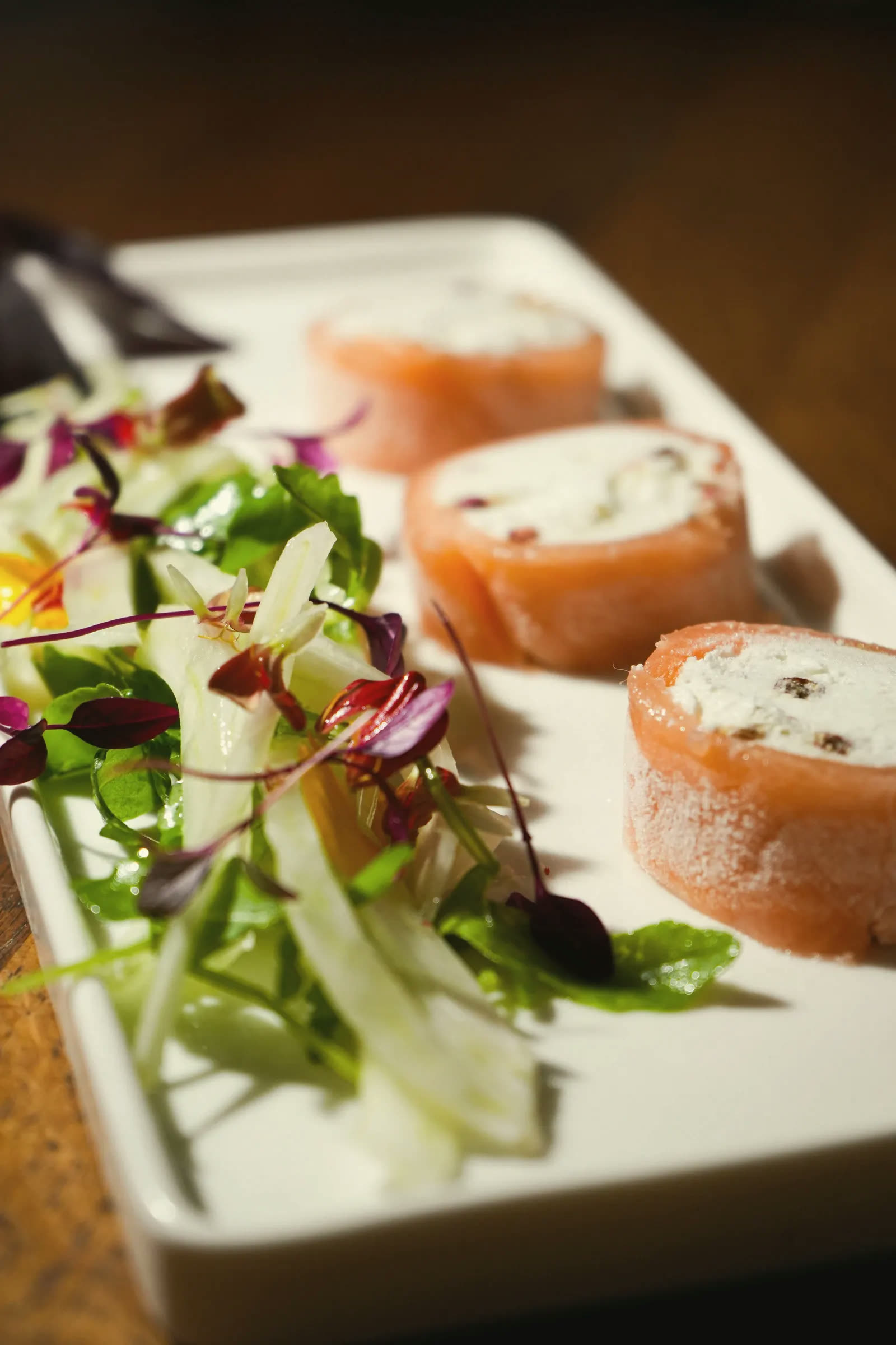 Smoked salmon rolls beside a fennel and young-shoot salad